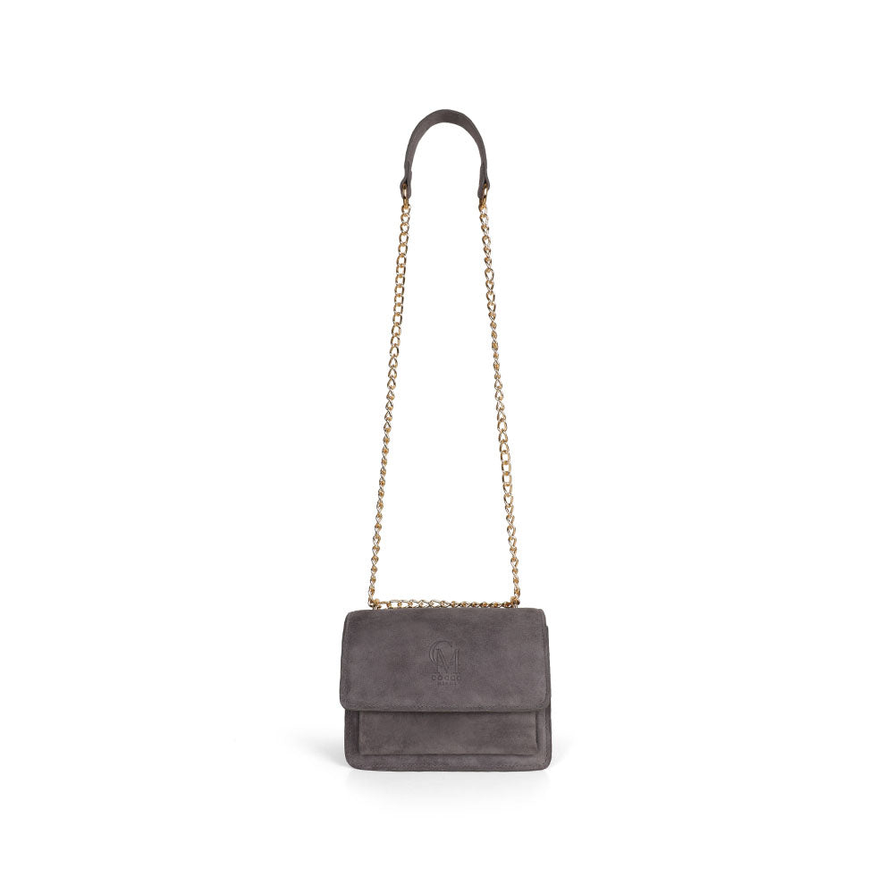 Blair gray suede bag hanging from its gold-tone chain strap
